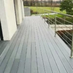 Aménagement de balcon à Cessy avec pose de terrasse en composite gris anthracite, pose de garde-corps et bandeau de finition